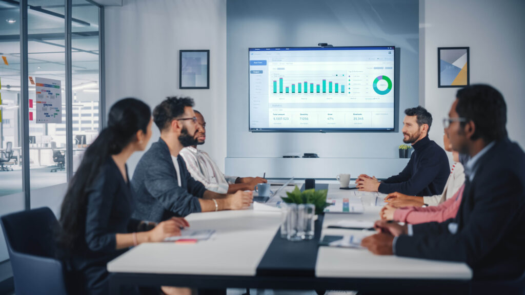 People at a meeting looking at a chart on a screen