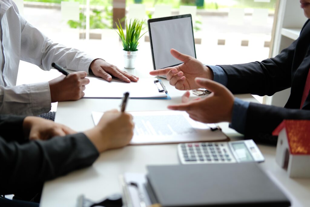 People at a desk taking notes and having a converstion