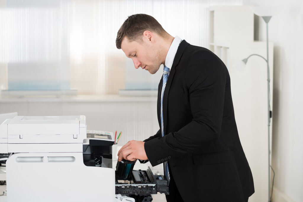 An employee adding a cartridge to a printer