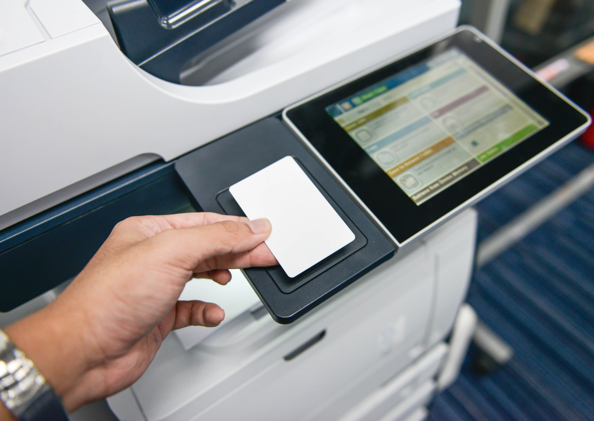 man scanning badge on copier printer machine